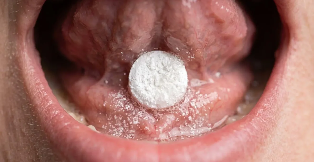 Close-up macro photograph of B12 sublingual tablet dissolving under tongue