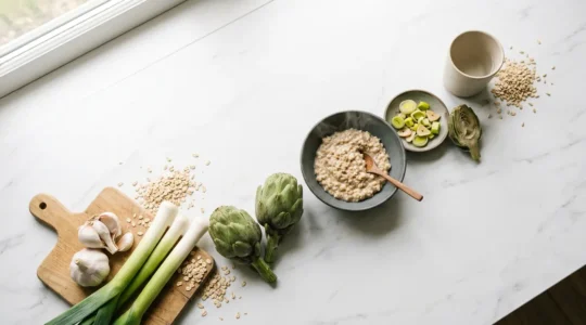 Diverse prebiotic-rich foods arranged in an artistic composition showing the journey from plate to gut